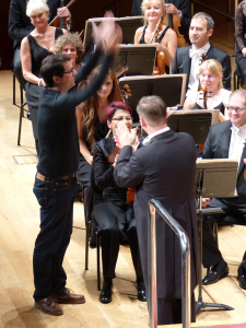 El compositor Fernando Velázquez dedicando los aplausos del público a La Coral de Bilbao. Foto: Pablo Cepeda